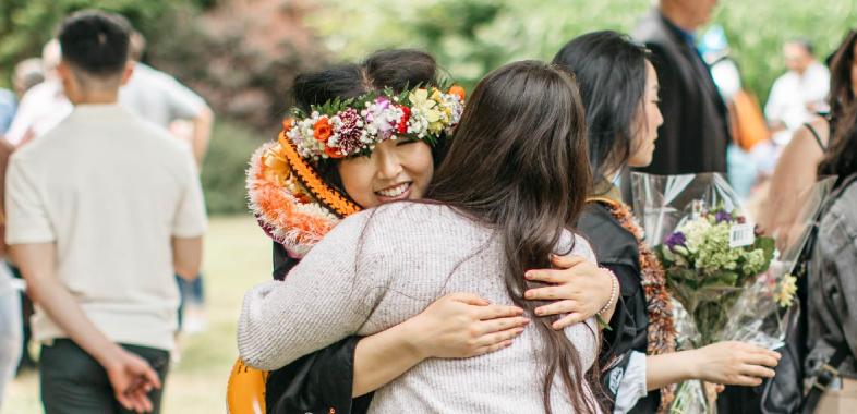 A graduate hugs their family member at commencement 