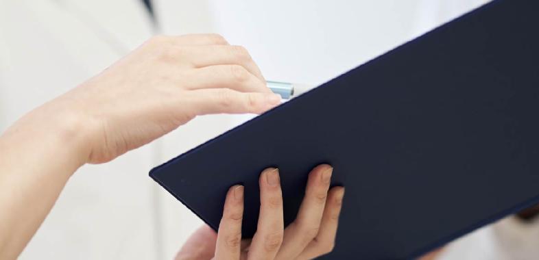 A woman holds and looks at a clipboard