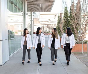 pharmacy students walking in white coats