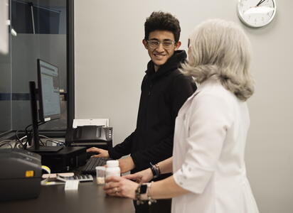 student smilies at a mentor while working at a computer