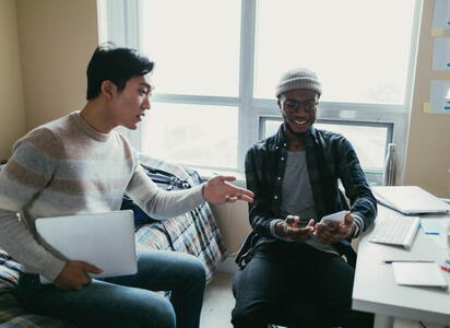 Two men hang out in a dormitory