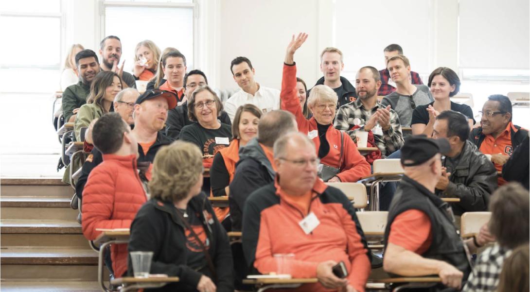 Someone raises their hand at an alumni event